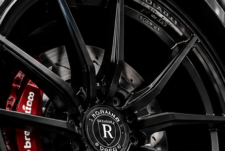Dark multi-spoke performance wheel with red brake caliper